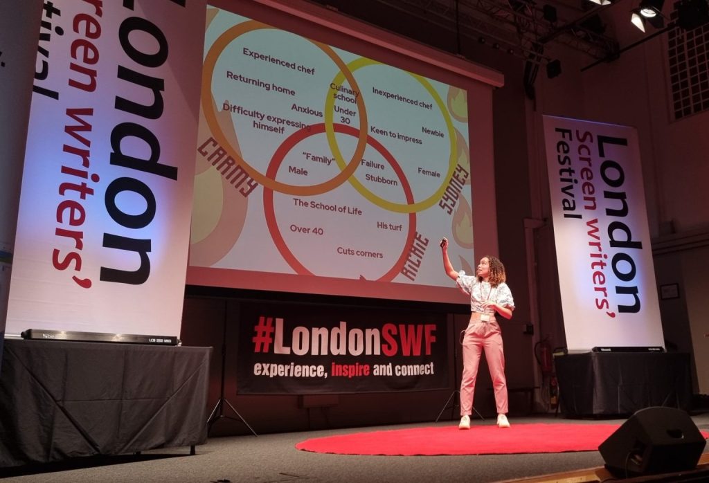 Gemma Mushington on stage showing a slide